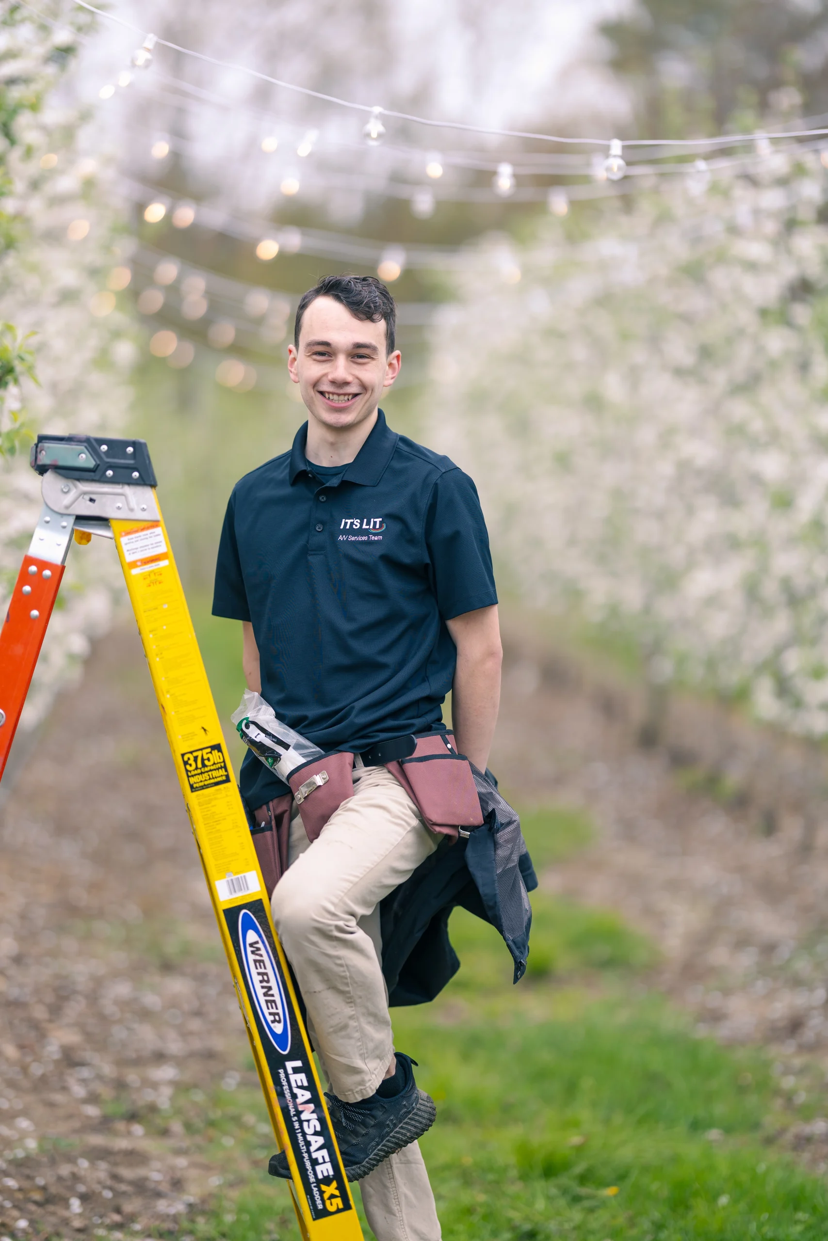av team member standing on ladder to install lighting