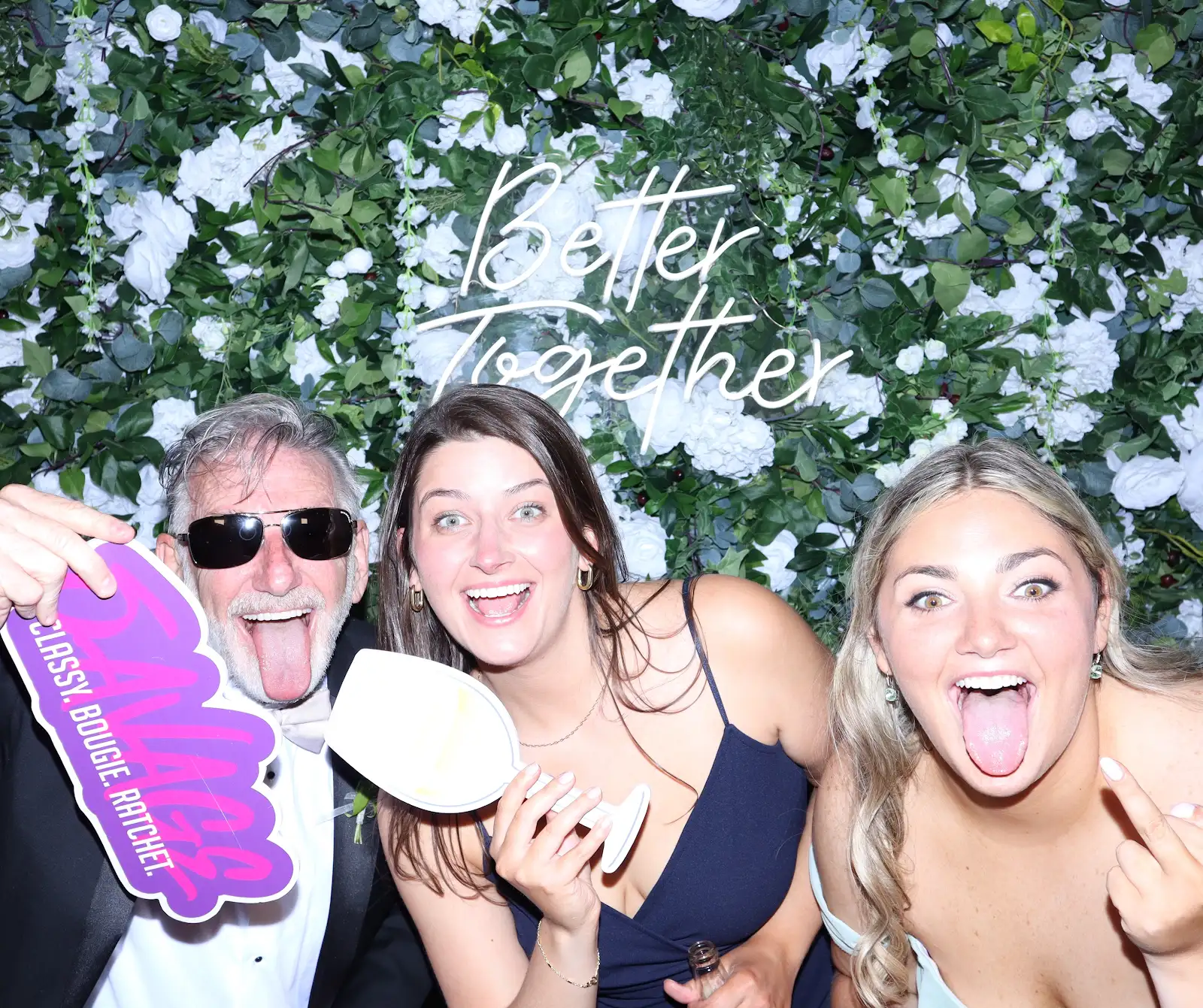 wedding guests pose with props in photo booth